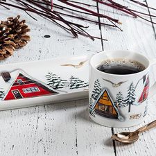 Une tasse a cafe et um plat avec motif de ski