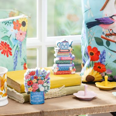Cottage Garden collection featuring wildflower bouquet figurine, stacked-books teapot decor, floral tea towels, and bird-print accessories
