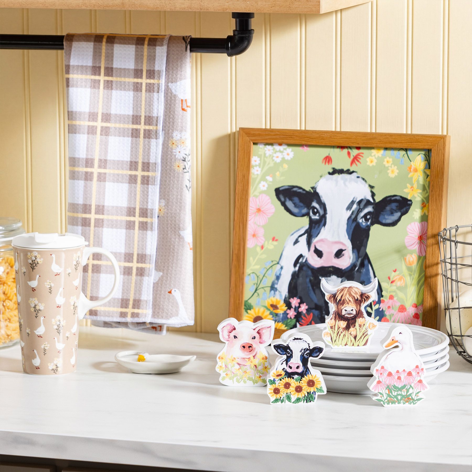 Hillside Pasture collection with farmhouse cow framed art, pig, cow, highland cow, and goose figurines, plaid towel, and goose-print travel mug