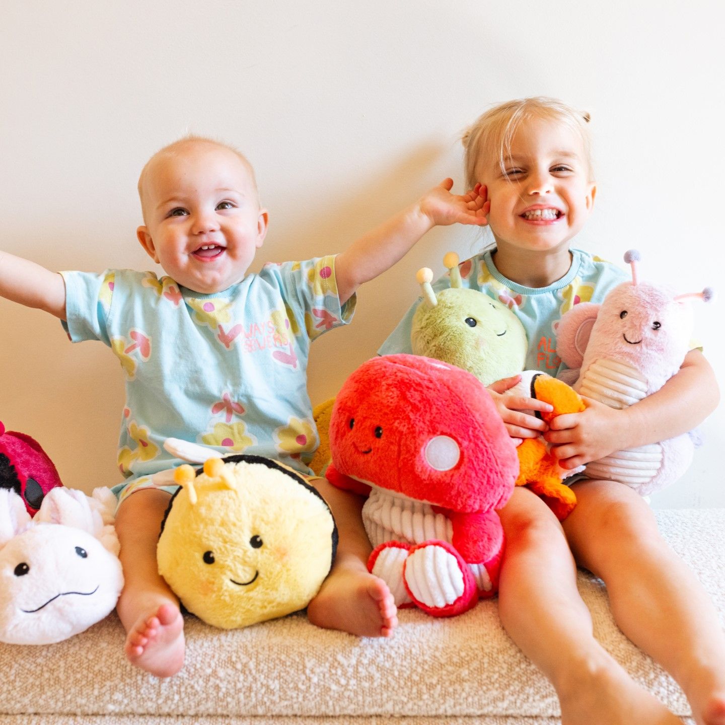 Two children smiling with stuffed animals