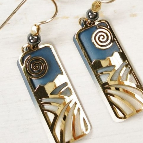 Pair of handcrafted rectangular earrings featuring gold and blue abstract landscape designs with spiral sun accents.